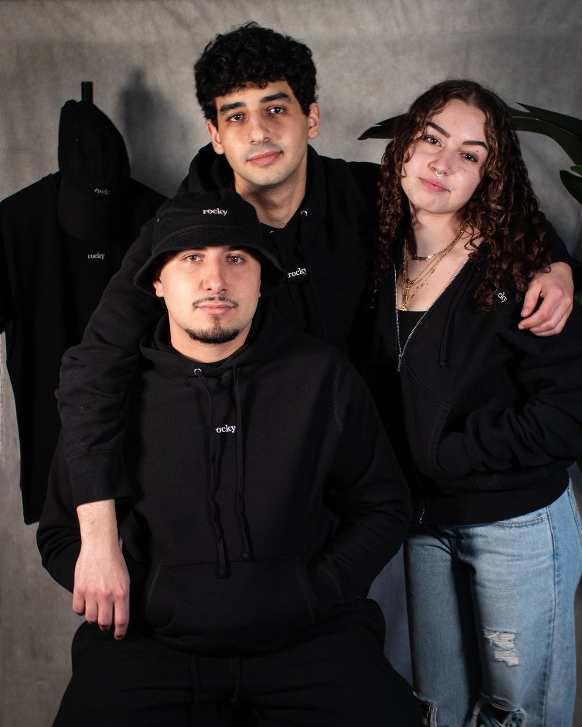Three people in black MyRocky merchandise with green plants